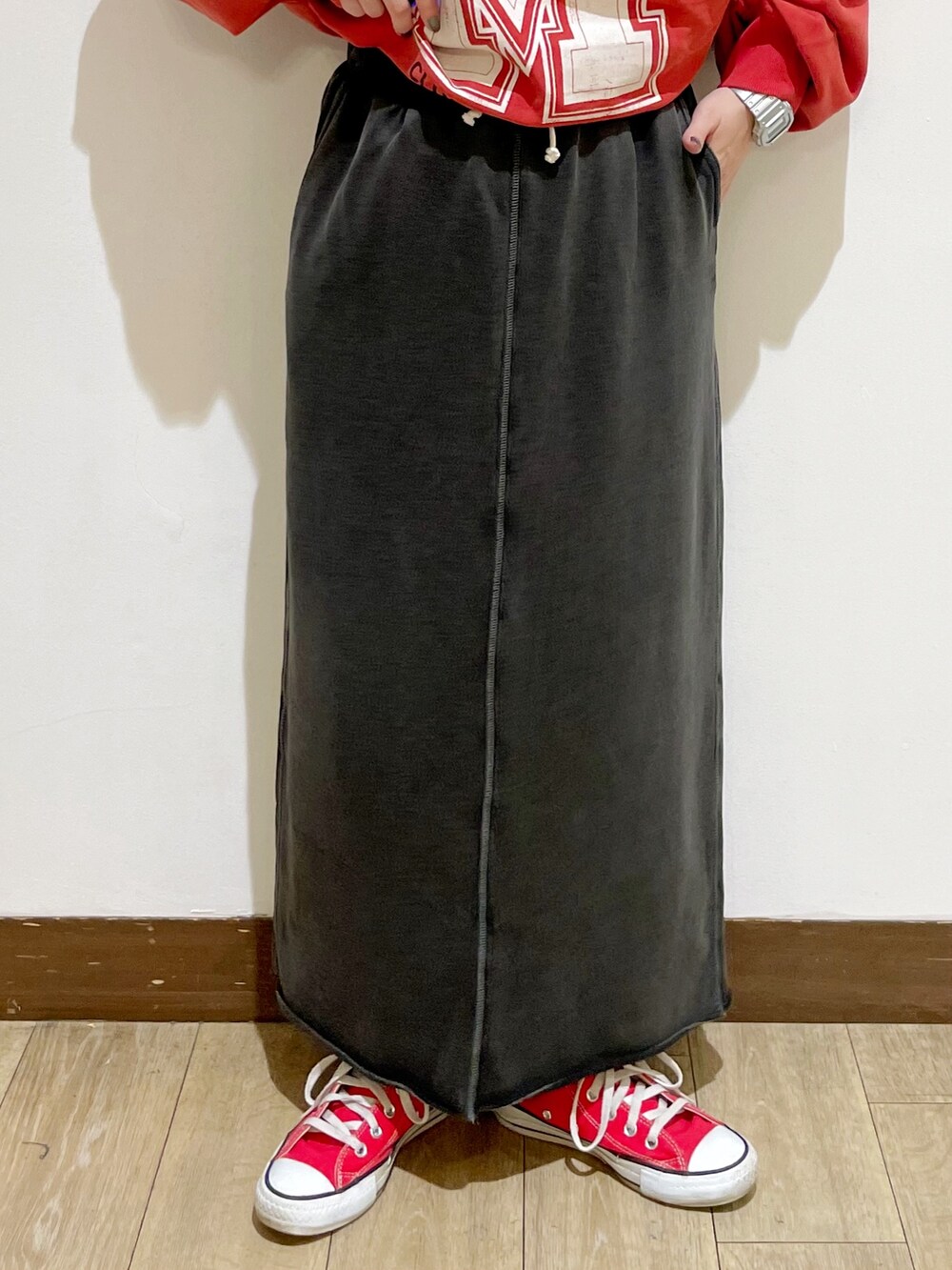 グレー系のパーカー、レッド系のスウェット、グレー系のスカートを着用したレディースの秋コーディネートの9枚目の写真