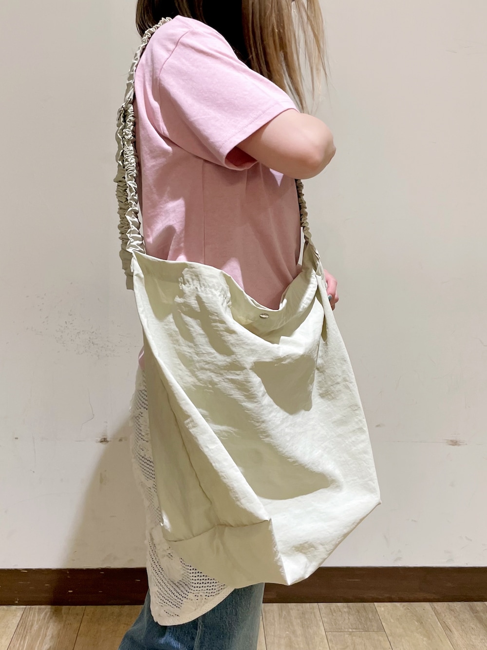 ピンク系のTシャツ/カットソー、ブルー系のデニムパンツ、ベージュ系のショルダーバッグを着用したレディースの夏コーディネートの3枚目の写真