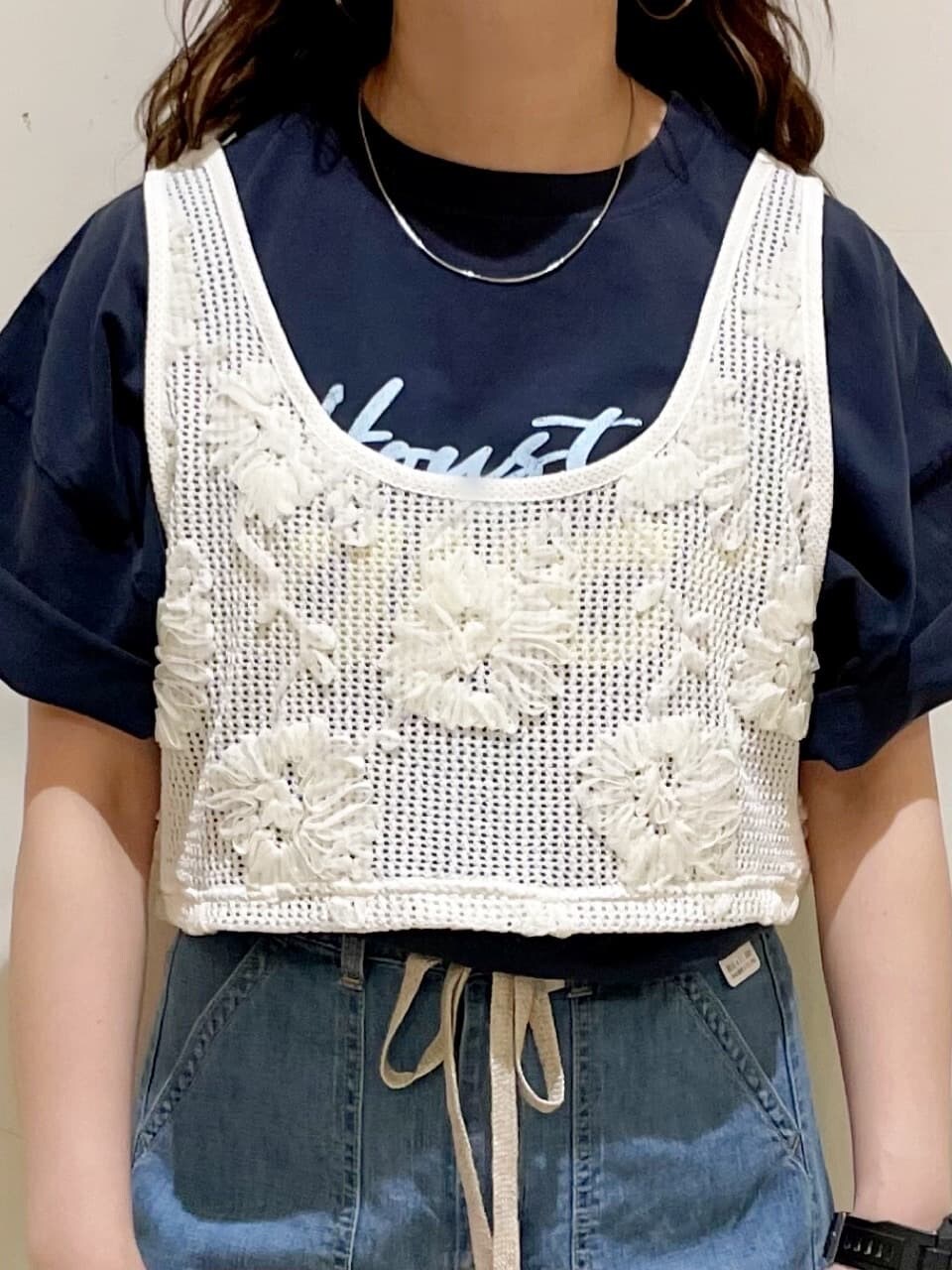 ブラウン系のショルダーバッグ、ブルー系のTシャツ/カットソー、ホワイト系のベストを着用したレディースの春コーディネートの5枚目の写真