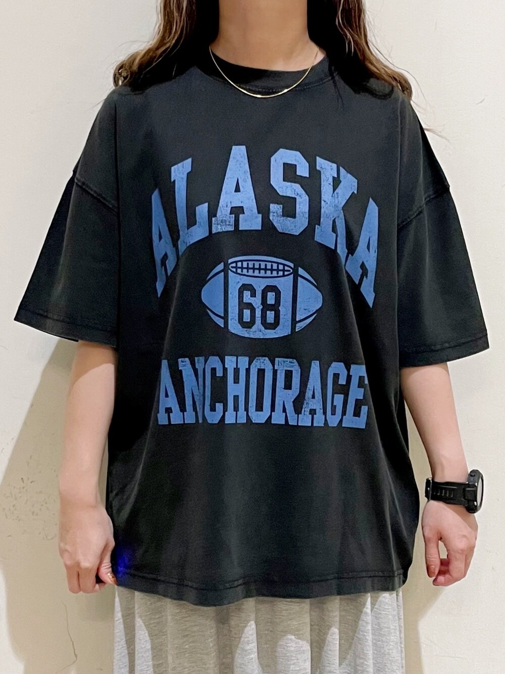 グレー系のTシャツ/カットソー、グレー系のスカート、ブラック系のサンダルを着用したレディースの夏コーディネートの7枚目の写真