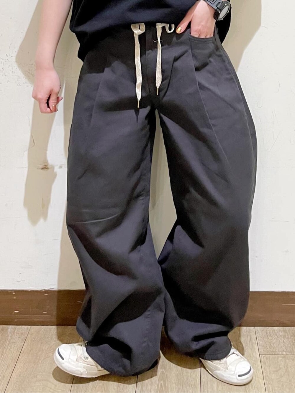 グレー系のショルダーバッグ、グレー系のその他パンツ、ブラック系のその他トップスを着用したレディースの春コーディネートの7枚目の写真