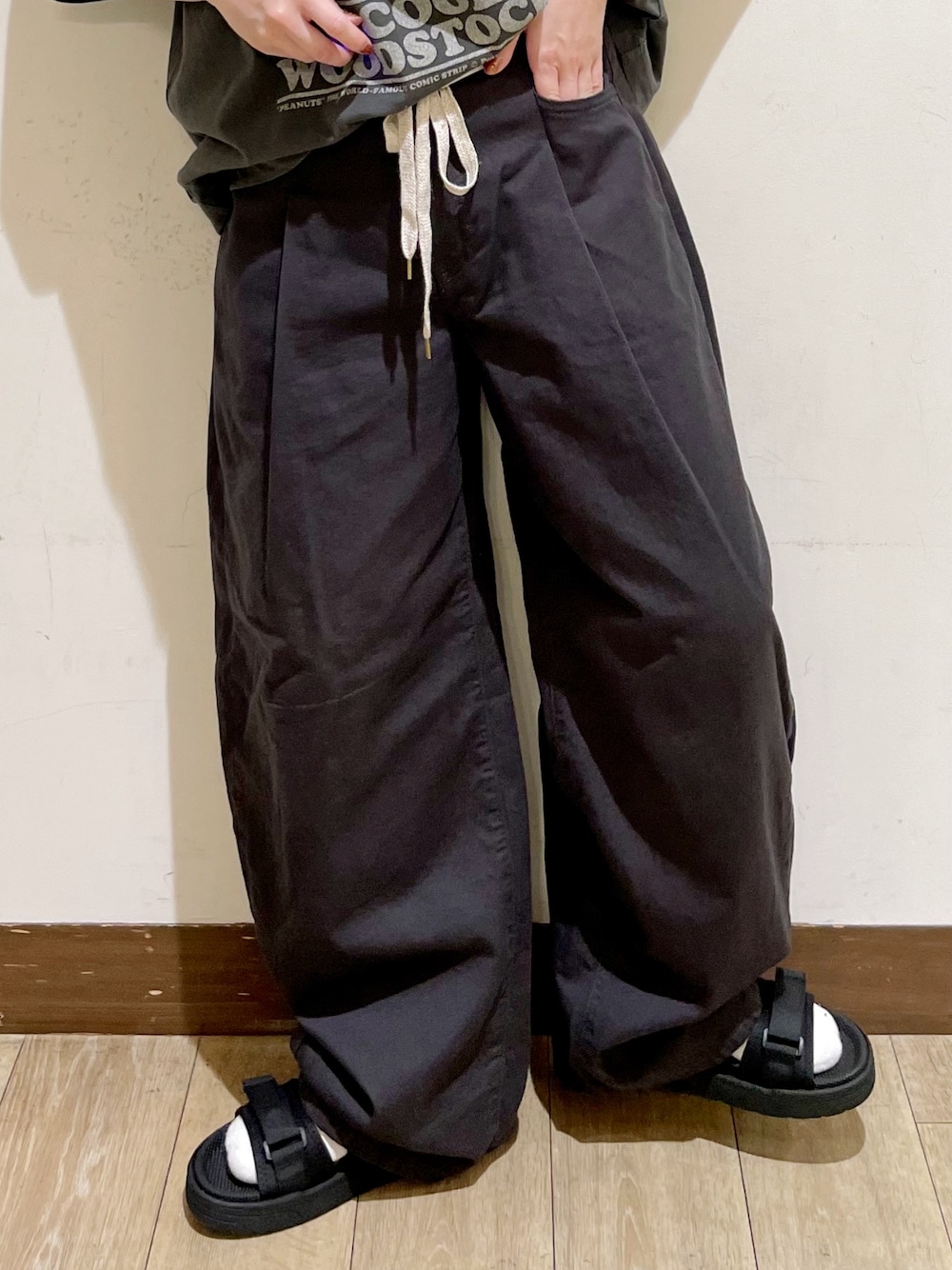 ブラック系のTシャツ/カットソー、グレー系のその他パンツ、ブラック系のサンダルを着用したレディースの夏コーディネートの9枚目の写真