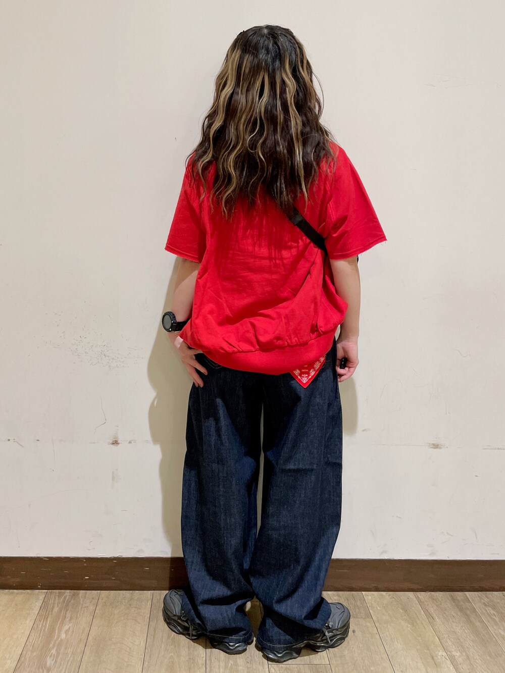 レッド系のTシャツ/カットソー、ブルー系のデニムパンツ、グリーン系のショルダーバッグを着用したレディースの夏コーディネートの2枚目の写真