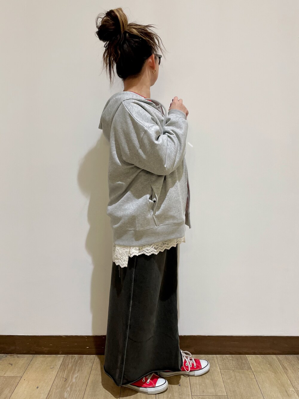 グレー系のパーカー、レッド系のスウェット、グレー系のスカートを着用したレディースの秋コーディネートの4枚目の写真