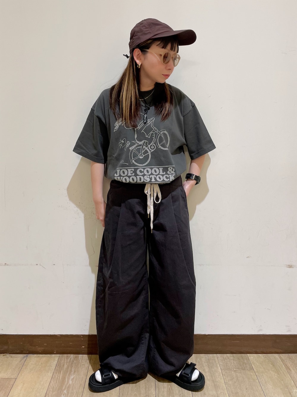 ブラック系のTシャツ/カットソー、グレー系のその他パンツ、ブラック系のサンダルを着用したレディースの夏コーディネートの8枚目の写真