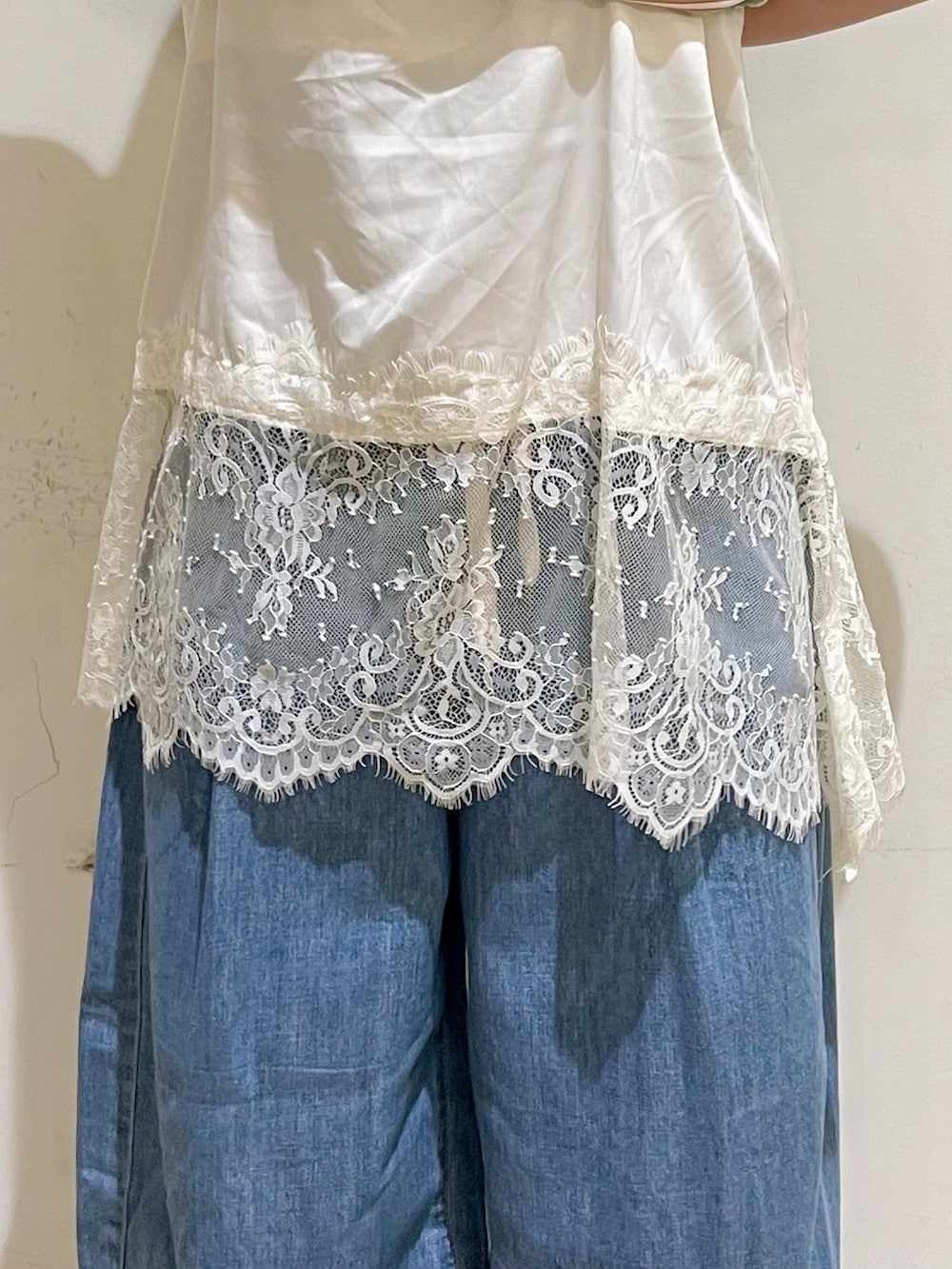 ブルー系のデニムパンツ、ベージュ系のショルダーバッグ、ブラック系のサンダルを着用したレディースの夏コーディネートの7枚目の写真