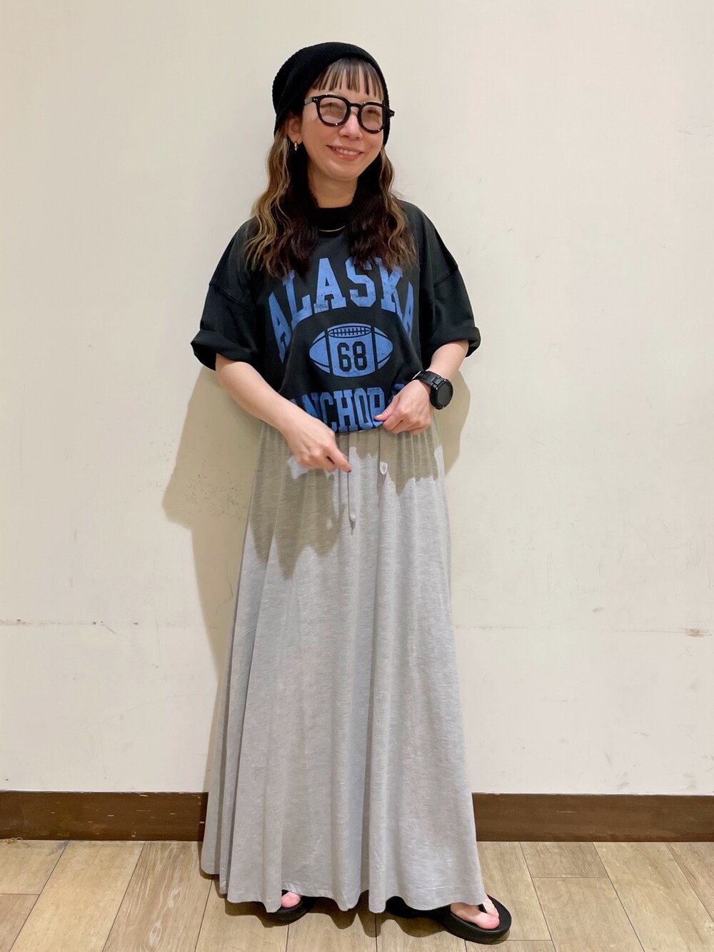 グレー系のTシャツ/カットソー、グレー系のスカート、ブラック系のサンダルを着用したレディースの夏コーディネートの5枚目の写真