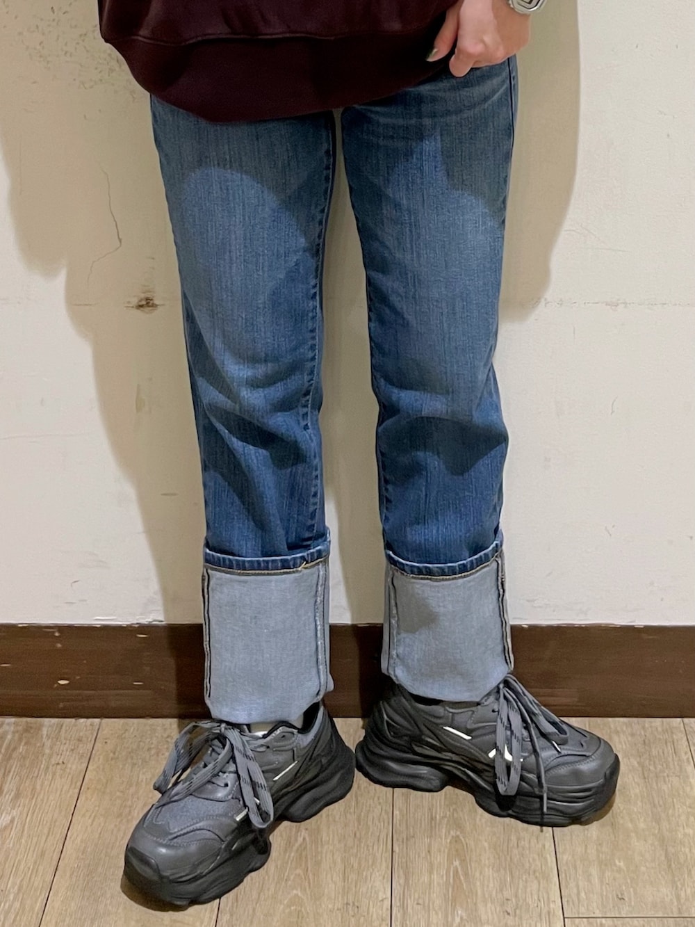 レッド系のスウェット、ブラック系のシャツ/ブラウス、ブルー系のデニムパンツを着用したレディースの秋コーディネートの9枚目の写真