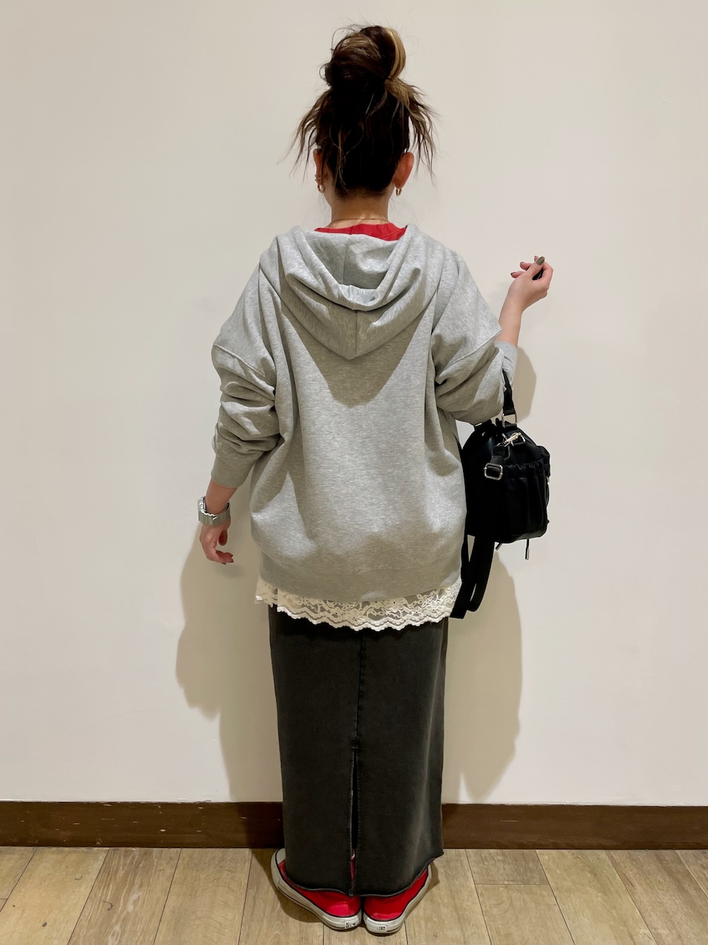 グレー系のパーカー、レッド系のスウェット、グレー系のスカートを着用したレディースの秋コーディネートの2枚目の写真