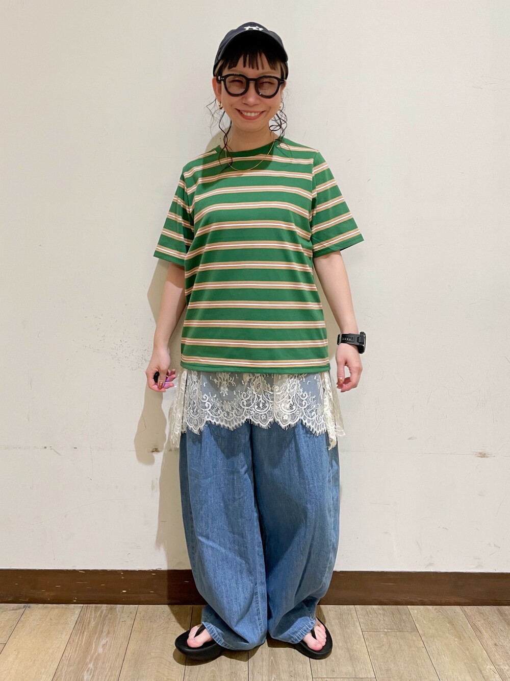 ブルー系のデニムパンツ、ベージュ系のショルダーバッグ、ブラック系のサンダルを着用したレディースの夏コーディネートの5枚目の写真