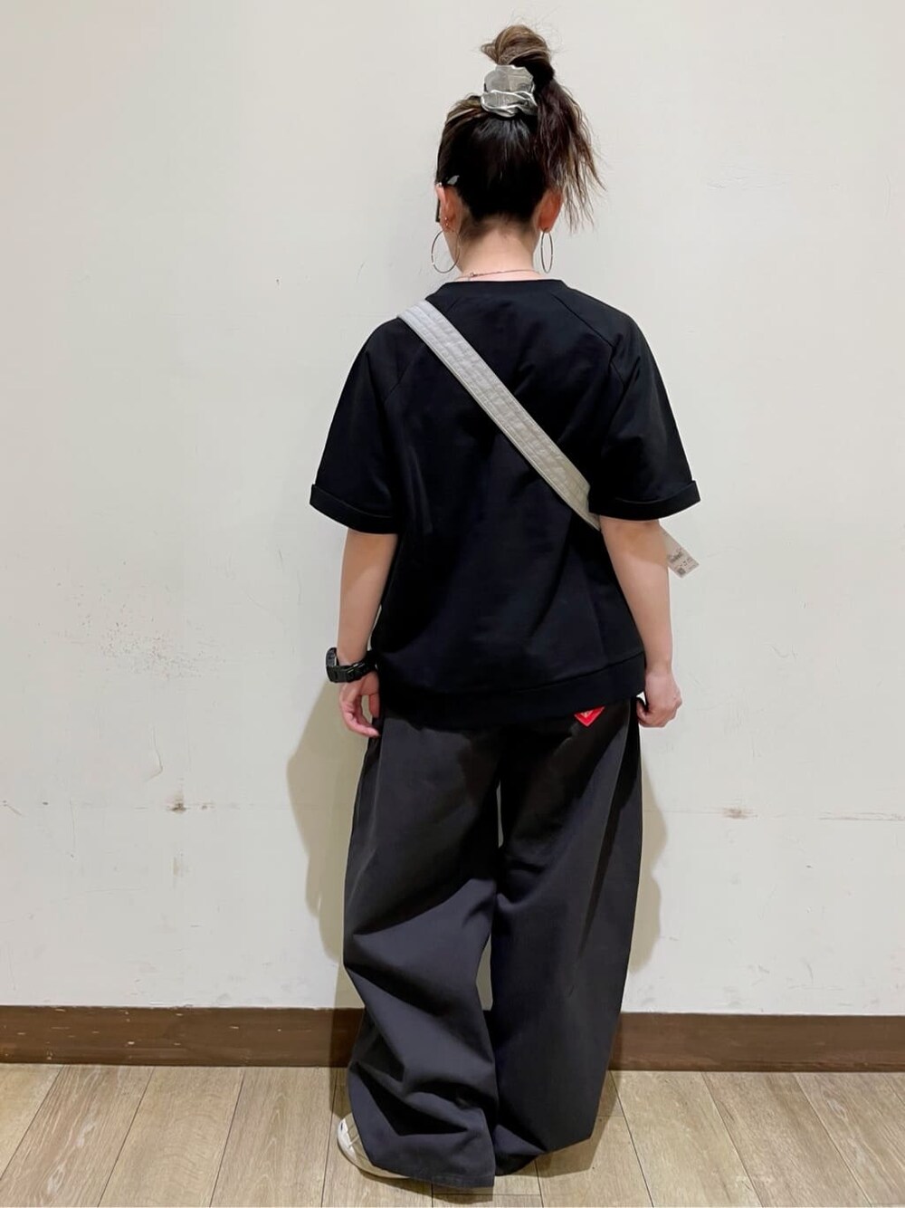 グレー系のショルダーバッグ、グレー系のその他パンツ、ブラック系のその他トップスを着用したレディースの春コーディネートの2枚目の写真