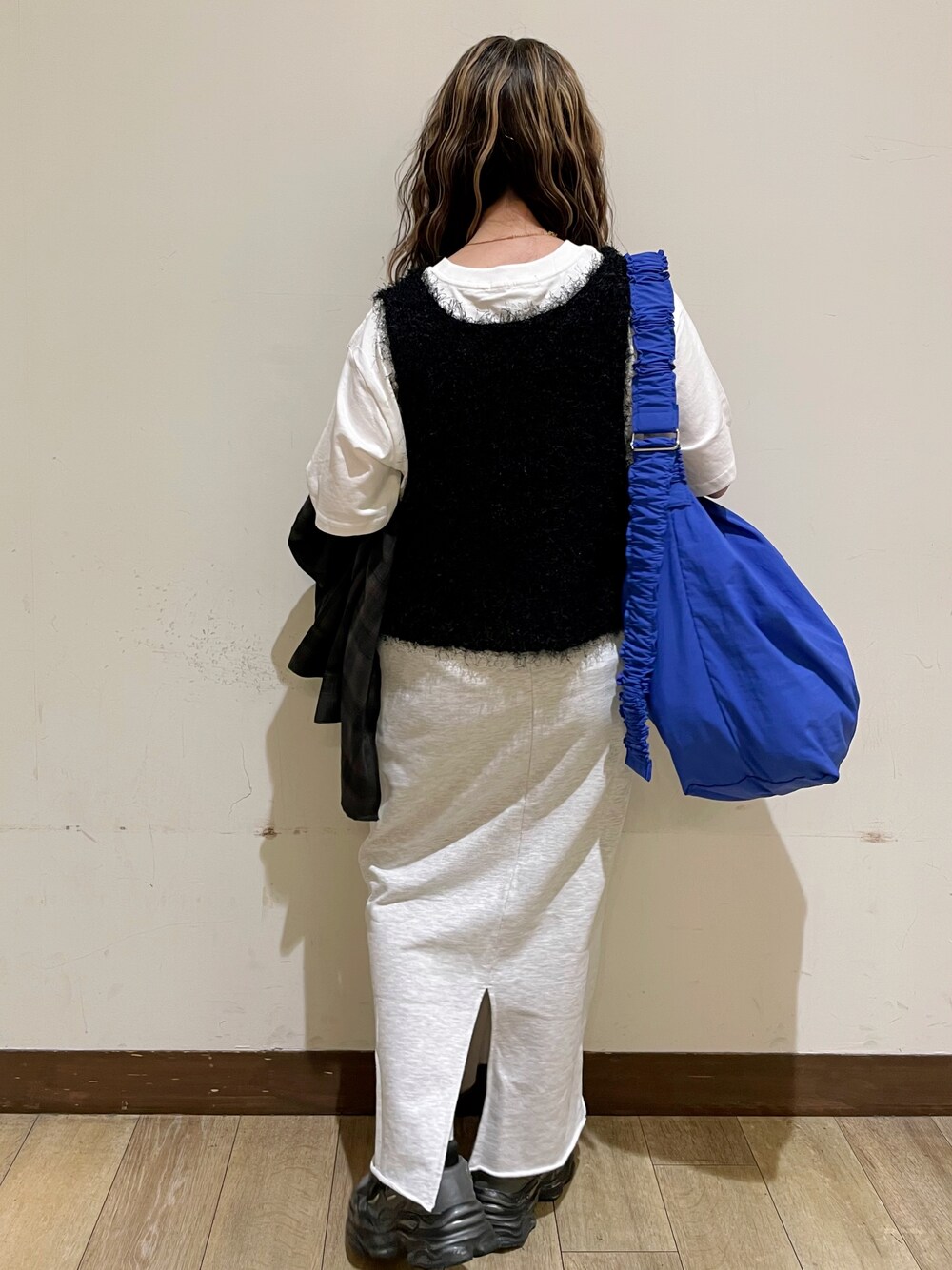 ブラウン系のシャツ/ブラウス、ホワイト系のTシャツ/カットソー、ブラック系のベストを着用したレディースの秋コーディネートの2枚目の写真