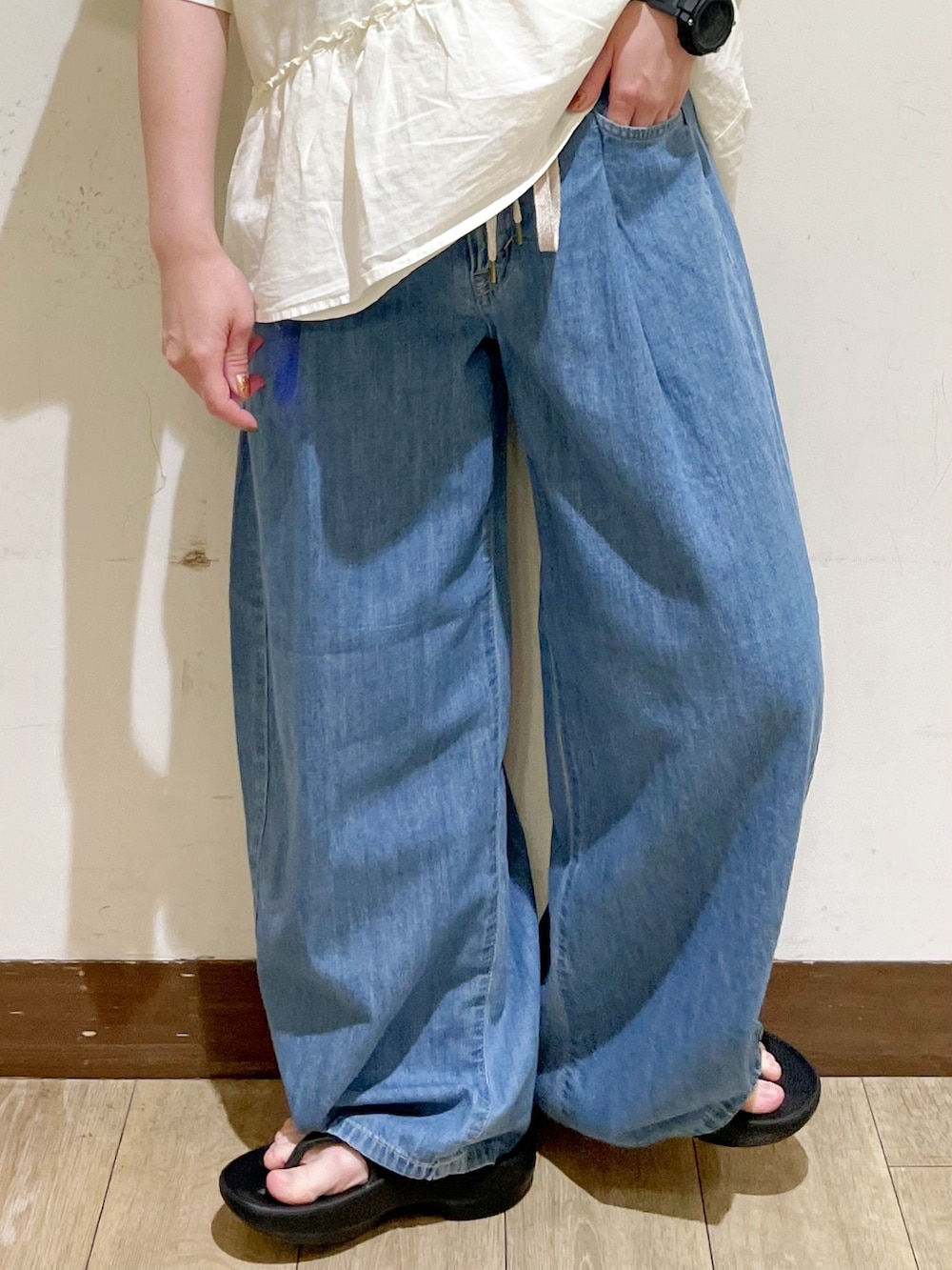 ホワイト系のTシャツ/カットソー、ブルー系のデニムパンツ、ブラック系のサンダルを着用したレディースの夏コーディネートの7枚目の写真