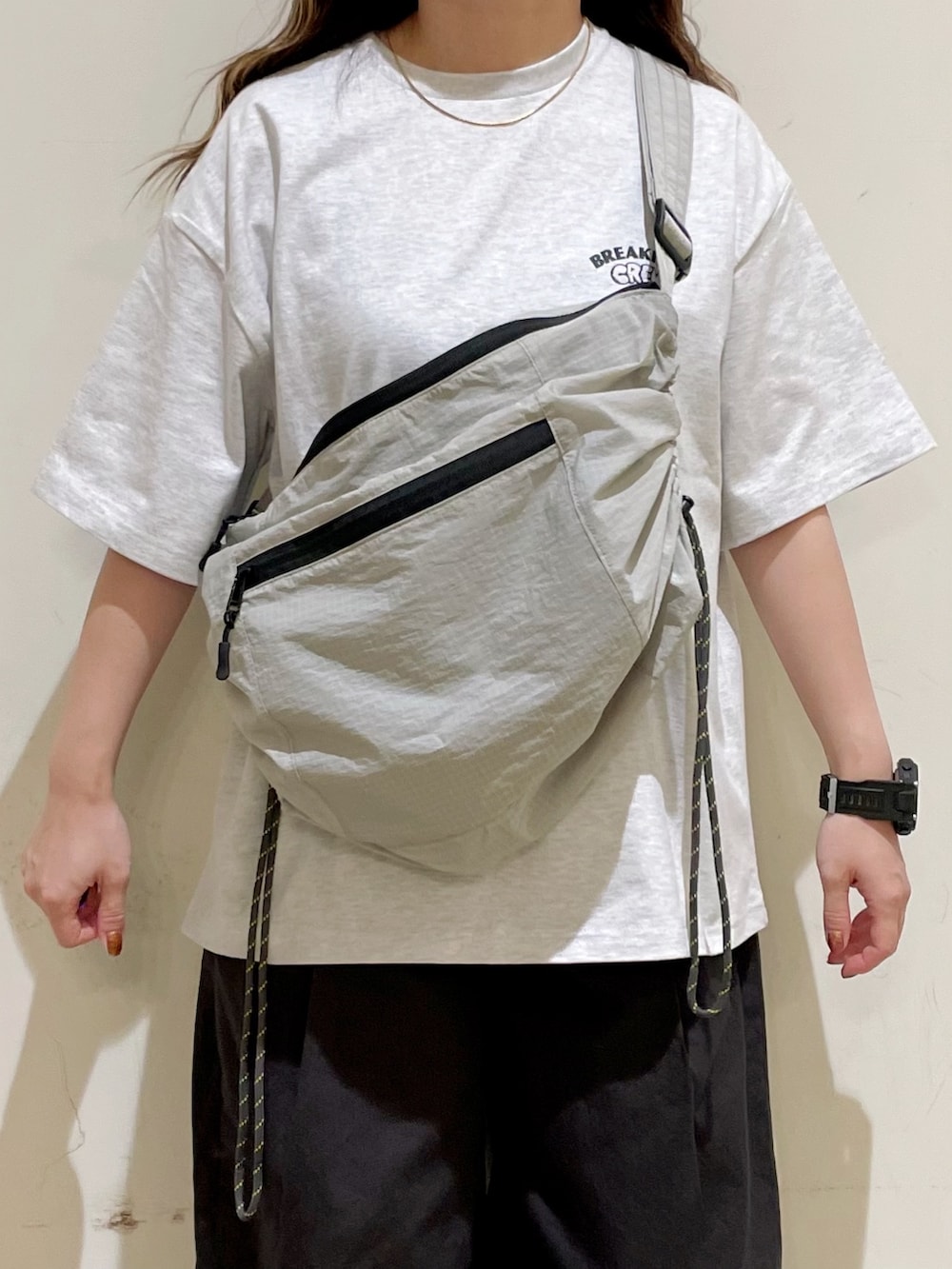 グレー系のTシャツ/カットソー、グレー系のその他パンツ、グレー系のショルダーバッグを着用したレディースの夏コーディネートの3枚目の写真