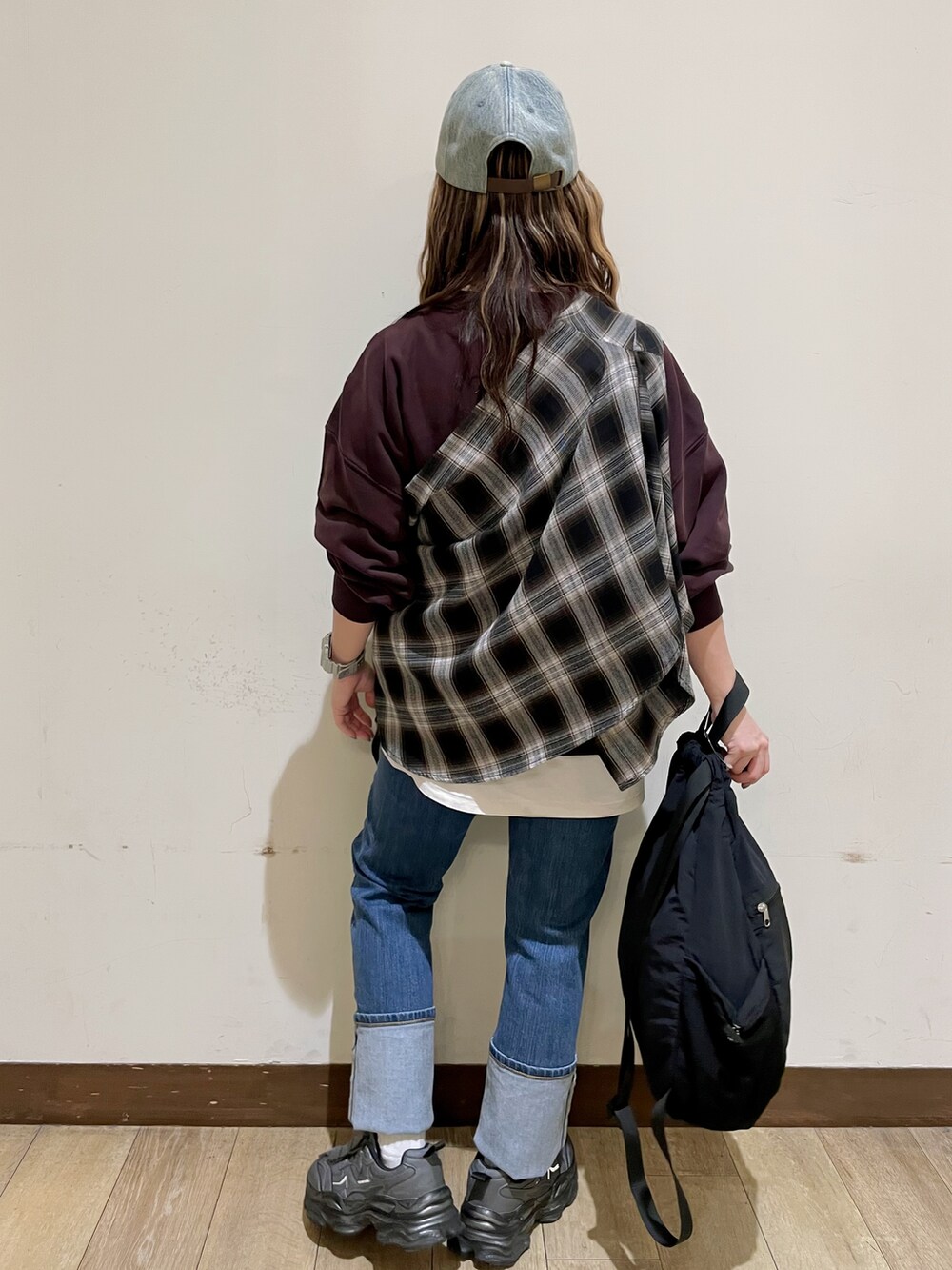 レッド系のスウェット、ブラック系のシャツ/ブラウス、ブルー系のデニムパンツを着用したレディースの秋コーディネートの2枚目の写真