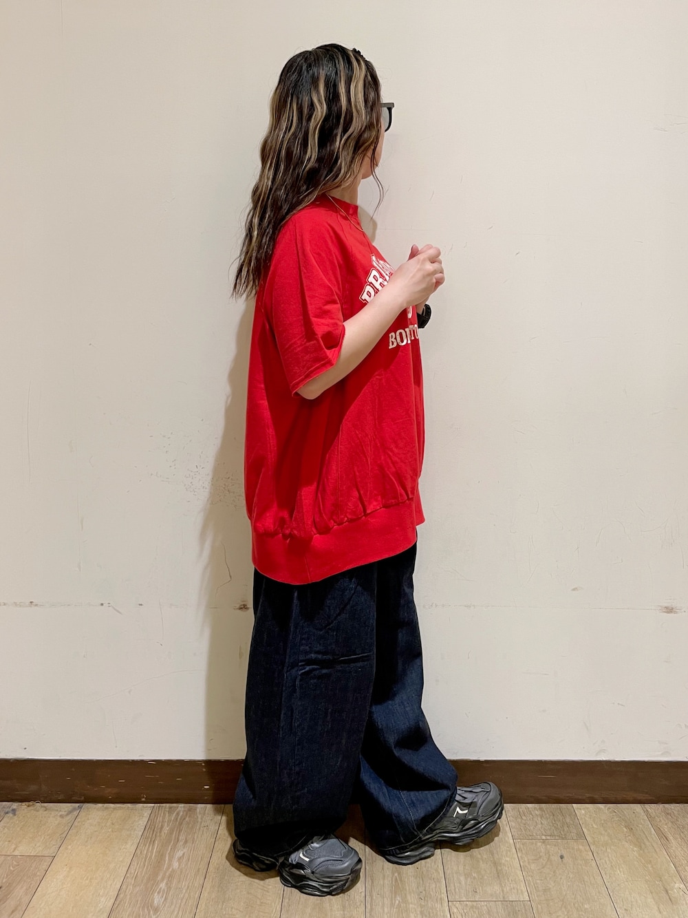 レッド系のTシャツ/カットソー、ブルー系のデニムパンツ、グリーン系のショルダーバッグを着用したレディースの夏コーディネートの4枚目の写真