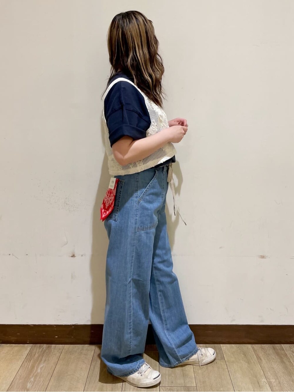 ブラウン系のショルダーバッグ、ブルー系のTシャツ/カットソー、ホワイト系のベストを着用したレディースの春コーディネートの4枚目の写真
