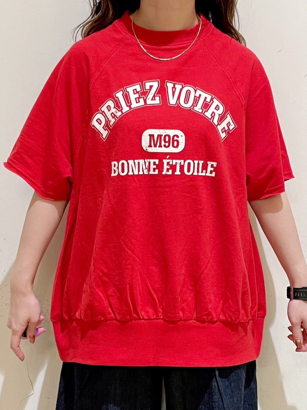 レッド系のTシャツ/カットソー、ブルー系のデニムパンツ、グリーン系のショルダーバッグを着用したレディースの夏コーディネートの6枚目の写真