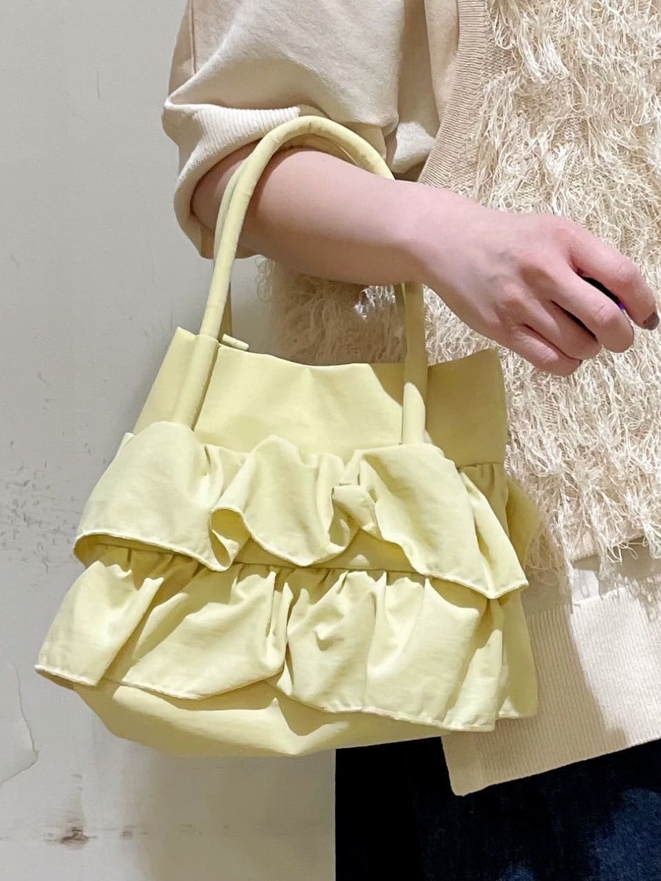 ホワイト系のベスト、ホワイト系のニット/セーター、ブルー系のデニムパンツを着用したレディースの春コーディネートの3枚目の写真