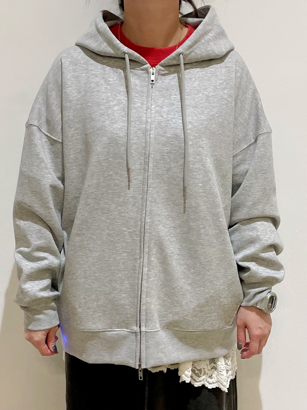 グレー系のパーカー、レッド系のスウェット、グレー系のスカートを着用したレディースの秋コーディネートの5枚目の写真