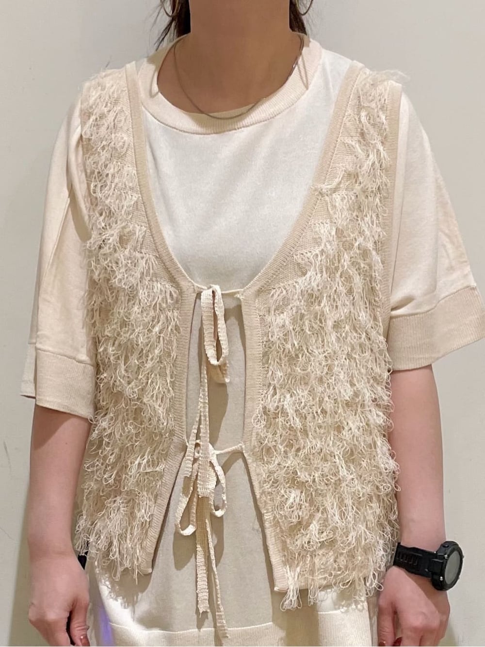 ホワイト系のベスト、ホワイト系のニット/セーター、ブルー系のデニムパンツを着用したレディースの春コーディネートの7枚目の写真