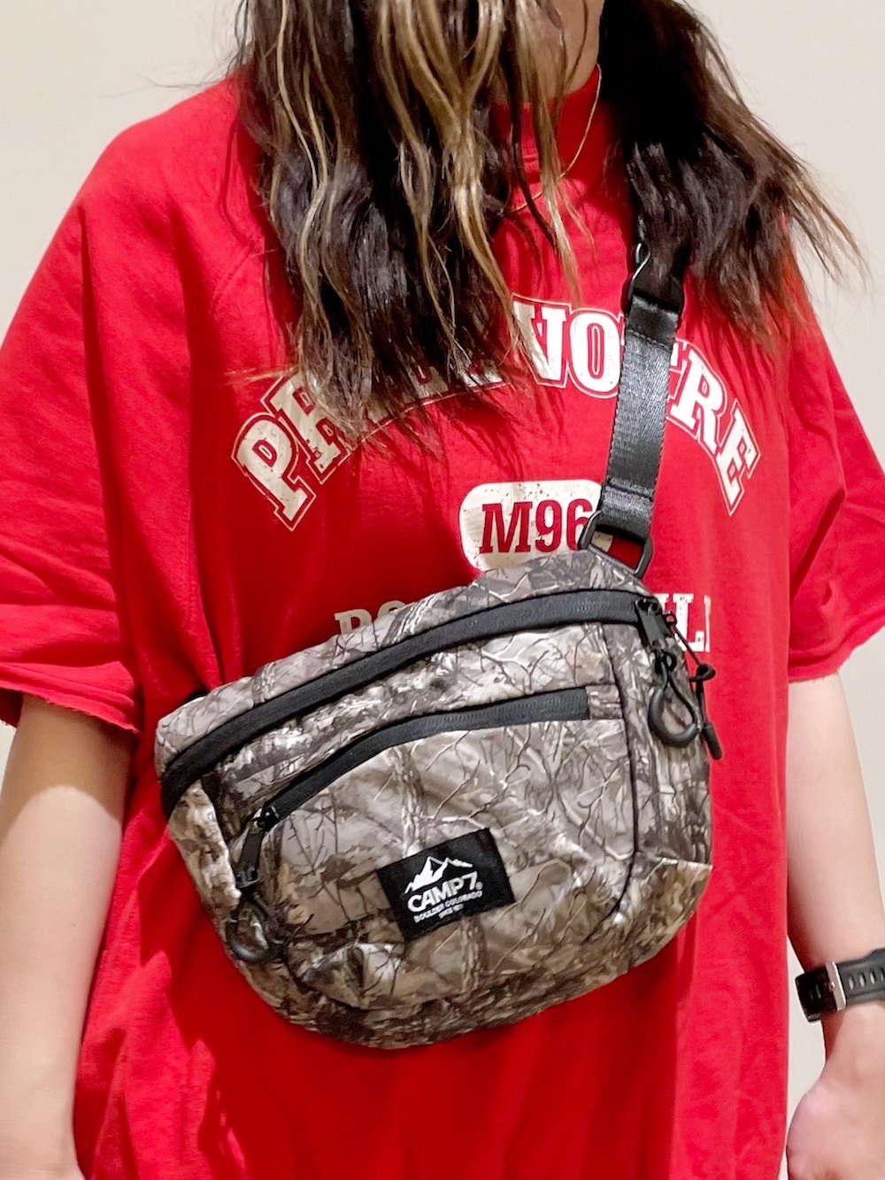 レッド系のTシャツ/カットソー、ブルー系のデニムパンツ、グリーン系のショルダーバッグを着用したレディースの夏コーディネートの3枚目の写真