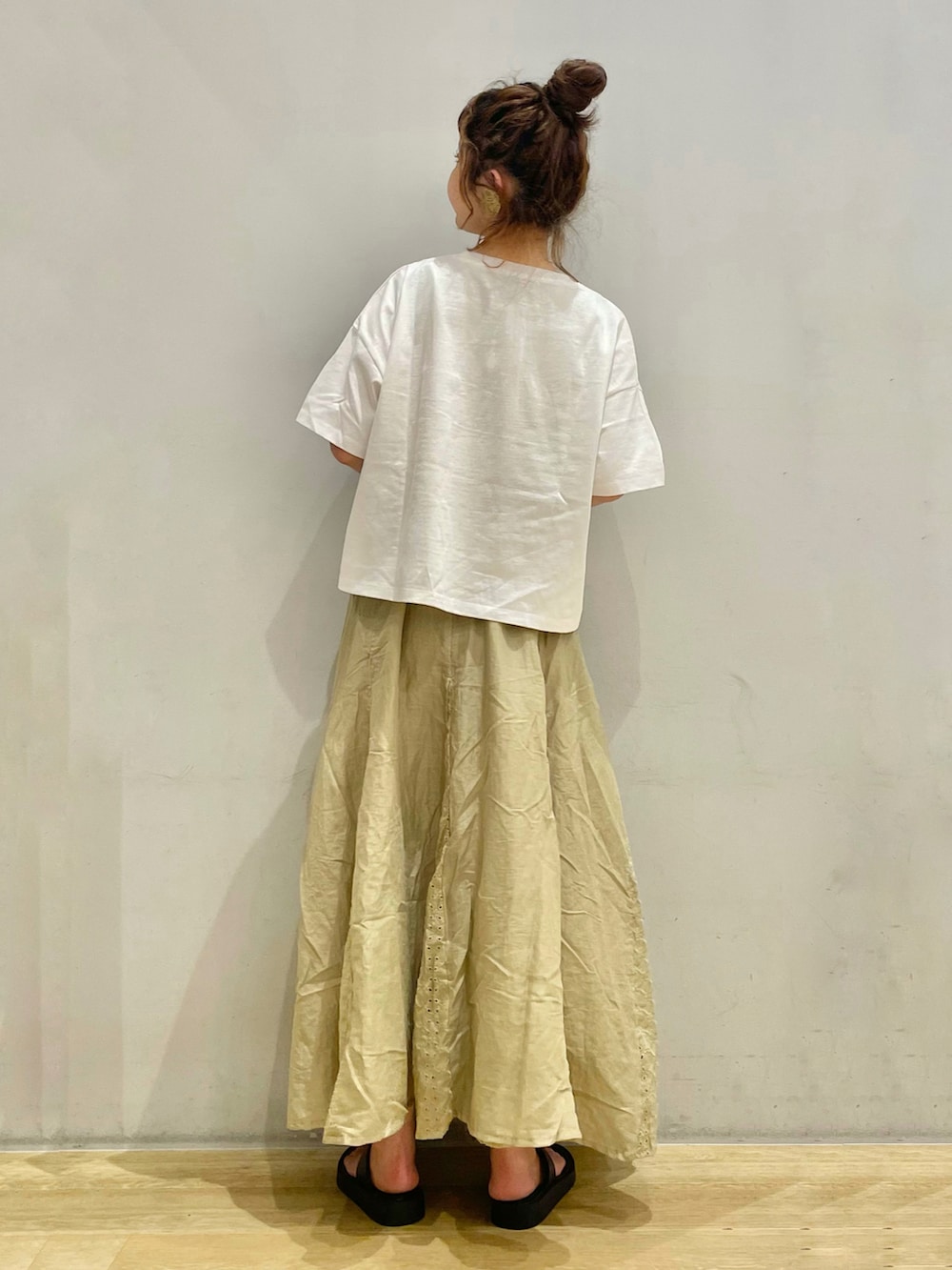 ホワイト系のTシャツ/カットソー、グリーン系のスカート、ブラック系のサンダルを着用したレディースの夏コーディネートの2枚目の写真