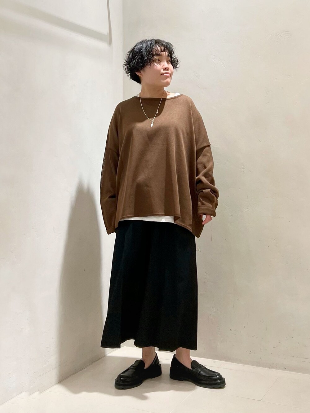 ブラック系のその他パンツ、ホワイト系のTシャツ/カットソー、ブラウン系のニット/セーターを着用したレディースの春コーディネートの3枚目の写真