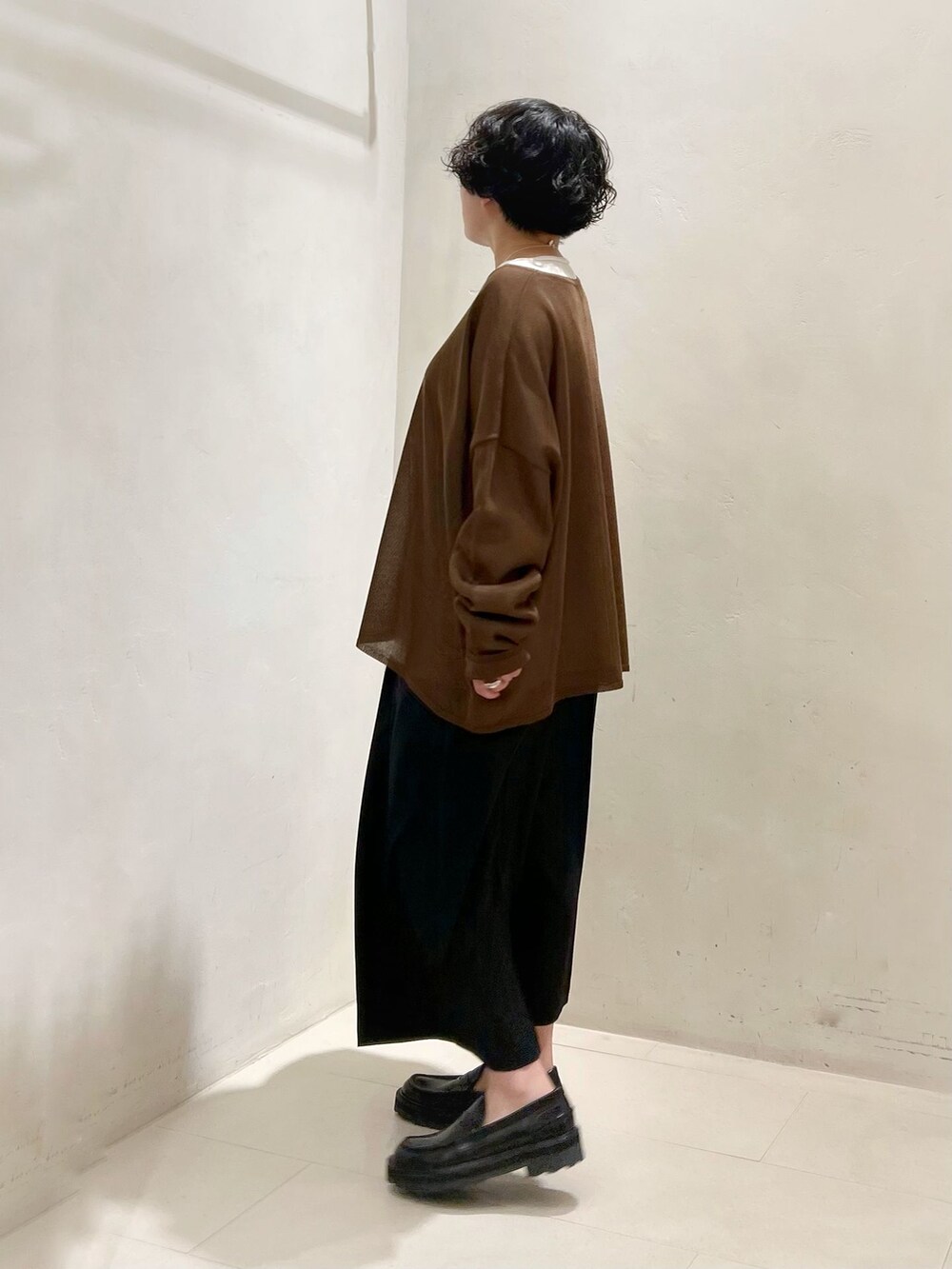 ブラック系のその他パンツ、ホワイト系のTシャツ/カットソー、ブラウン系のニット/セーターを着用したレディースの春コーディネートの2枚目の写真
