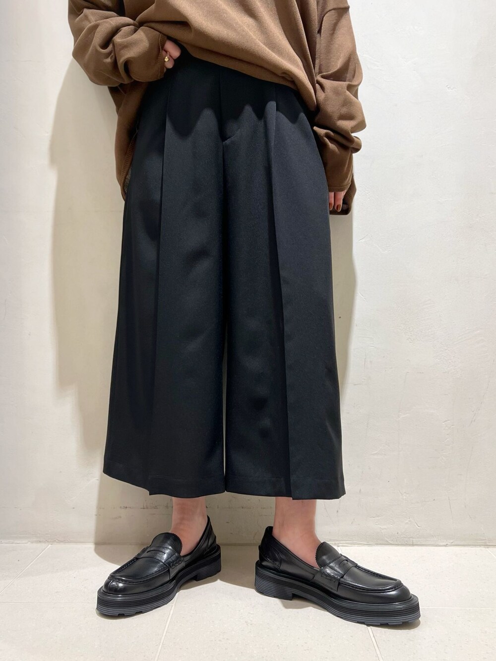 ブラック系のその他パンツ、ホワイト系のTシャツ/カットソー、ブラウン系のニット/セーターを着用したレディースの春コーディネートの8枚目の写真
