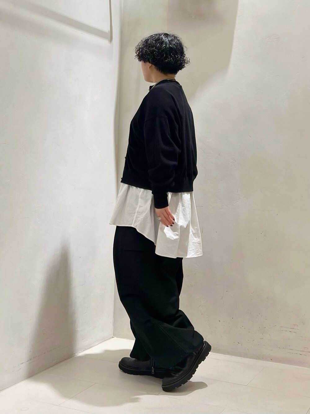 ブラック系のカーゴパンツ、ホワイト系のシャツ/ブラウス、ブラック系のニット/セーターを着用したレディースの冬コーディネートの2枚目の写真