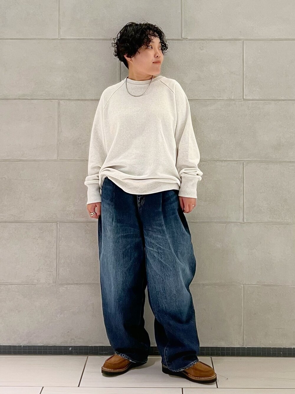 ブルー系のデニムパンツを着用したレディースの秋コーディネートの2枚目の写真