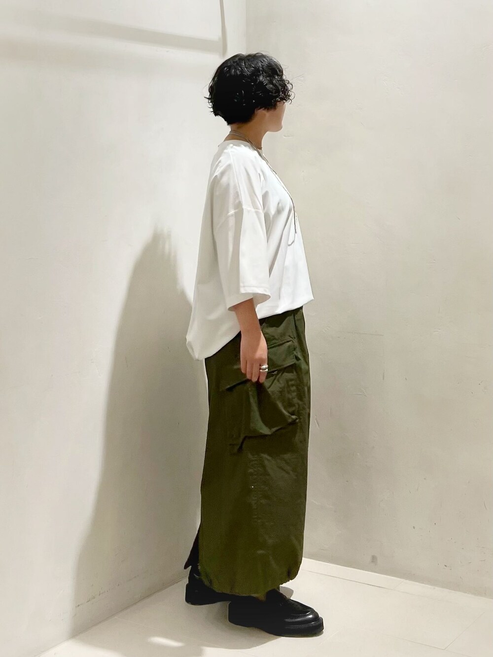 グリーン系のスカート、ホワイト系のTシャツ/カットソーを着用したレディースの夏コーディネートの4枚目の写真