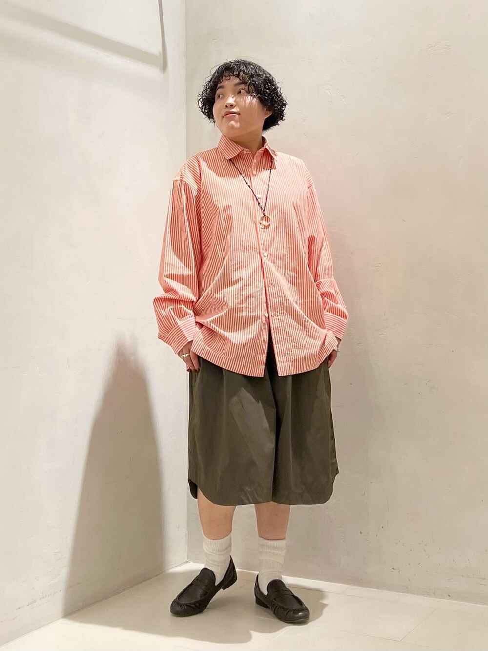 グリーン系のその他パンツ、オレンジ系のシャツ/ブラウス、ホワイト系のソックス/靴下を着用したレディースの冬コーディネートの3枚目の写真