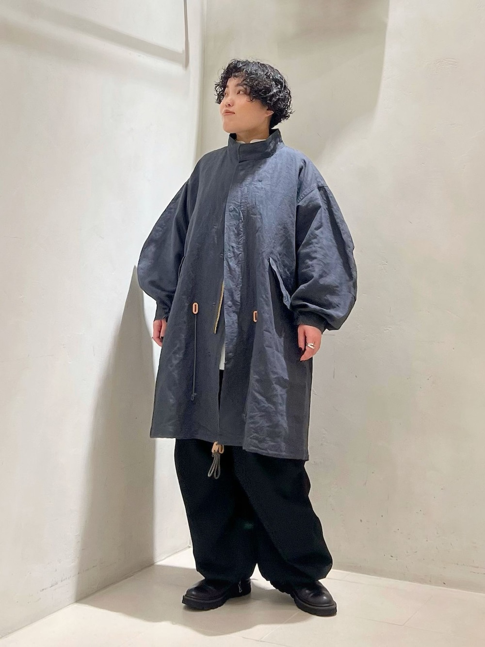 ブラック系のカーゴパンツ、ホワイト系のシャツ/ブラウス、ブラック系のニット/セーターを着用したレディースの冬コーディネートの3枚目の写真