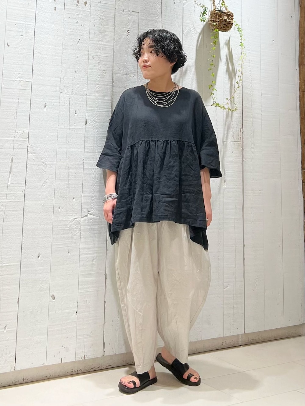 グレー系のその他パンツ、ブラック系のシャツ/ブラウス、ブラック系のかごバッグを着用したレディースの夏コーディネートの5枚目の写真
