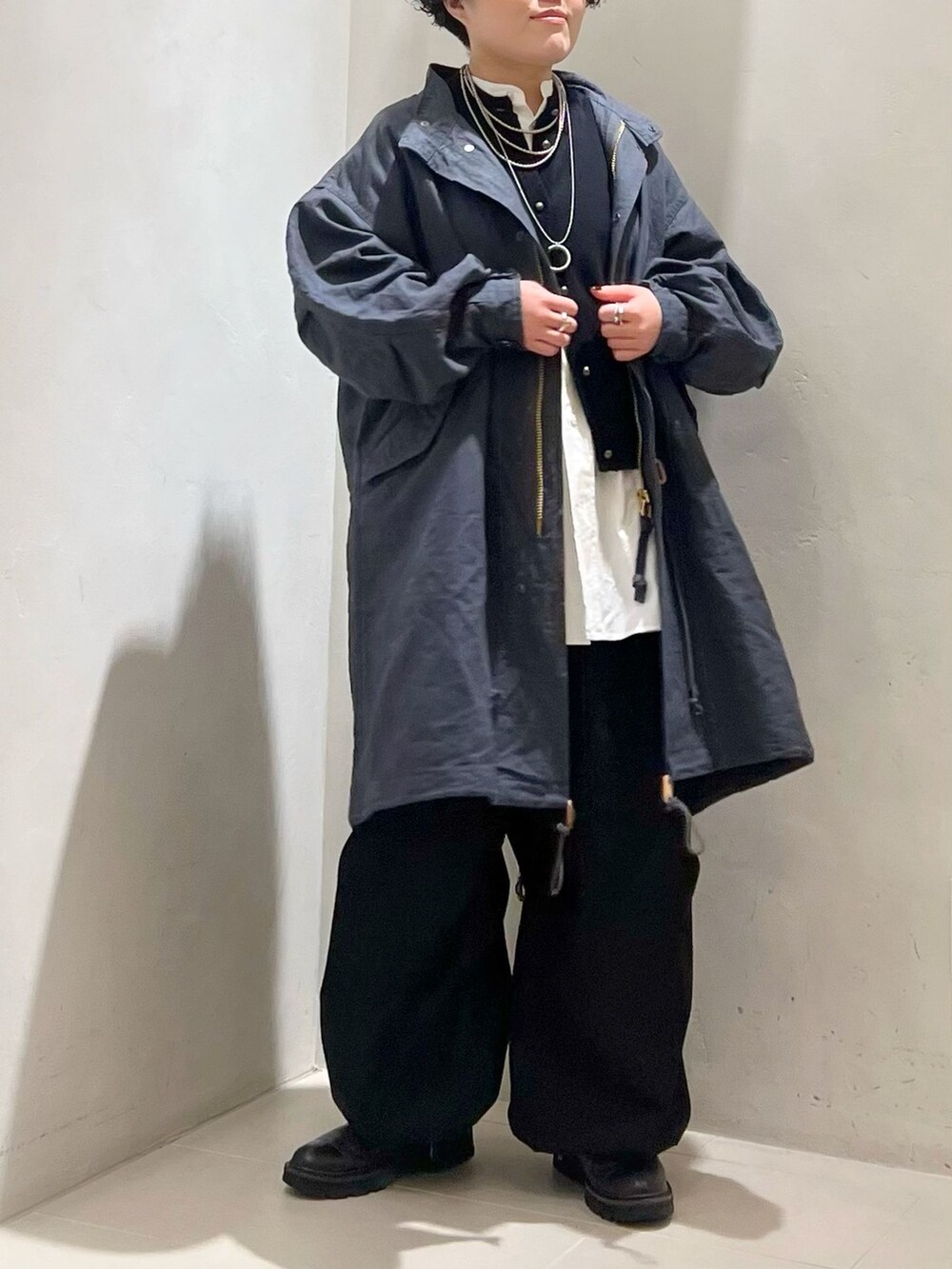 ブラック系のカーゴパンツ、ホワイト系のシャツ/ブラウス、ブラック系のニット/セーターを着用したレディースの冬コーディネートの4枚目の写真