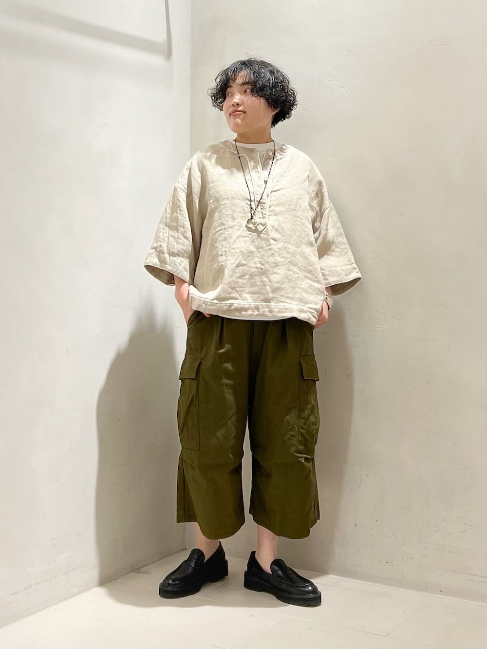 グリーン系のカーゴパンツ、ホワイト系のTシャツ/カットソーを着用したレディースの春コーディネートの3枚目の写真