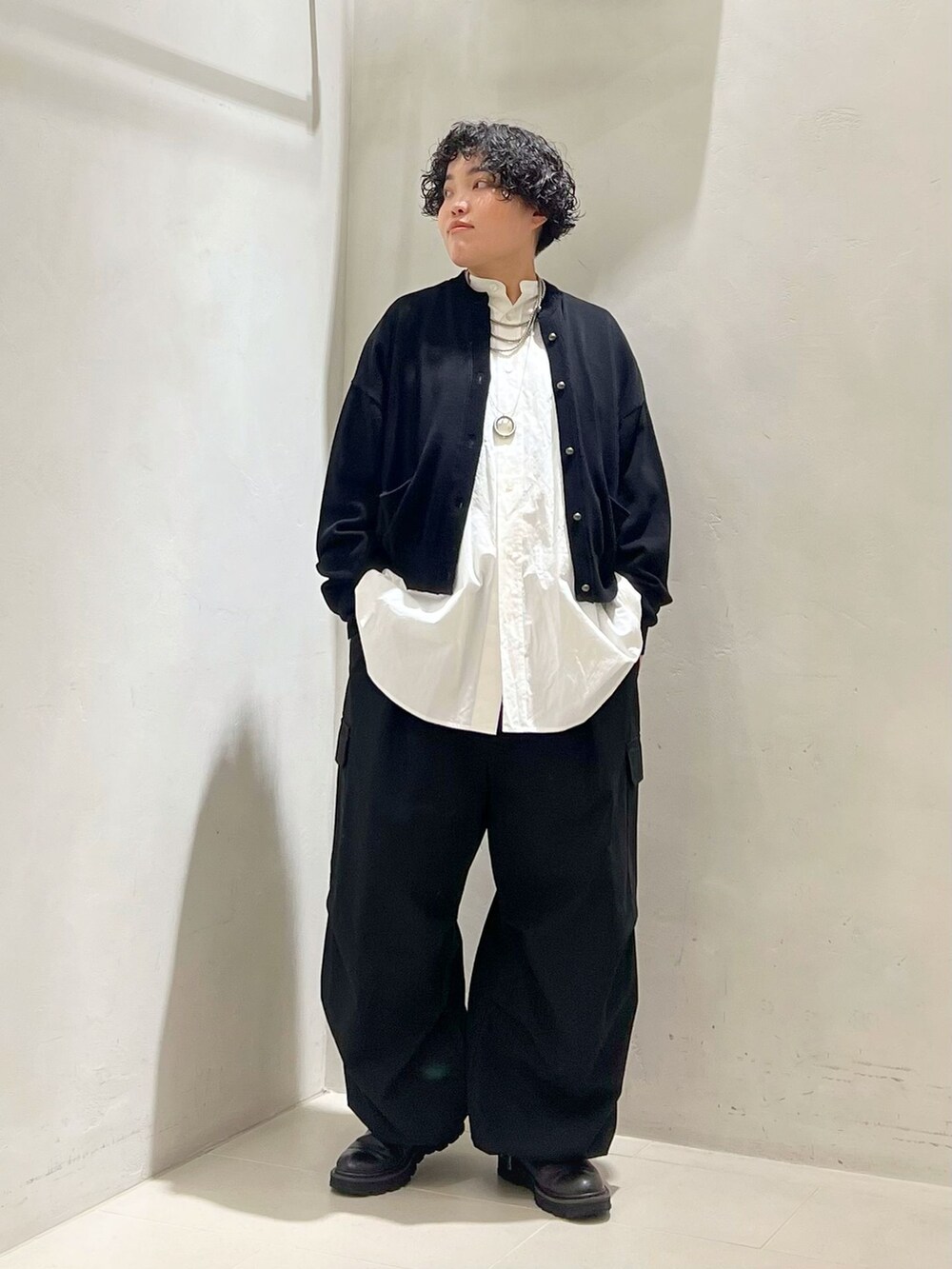 ブラック系のカーゴパンツ、ホワイト系のシャツ/ブラウス、ブラック系のニット/セーターを着用したレディースの冬コーディネートの3枚目の写真