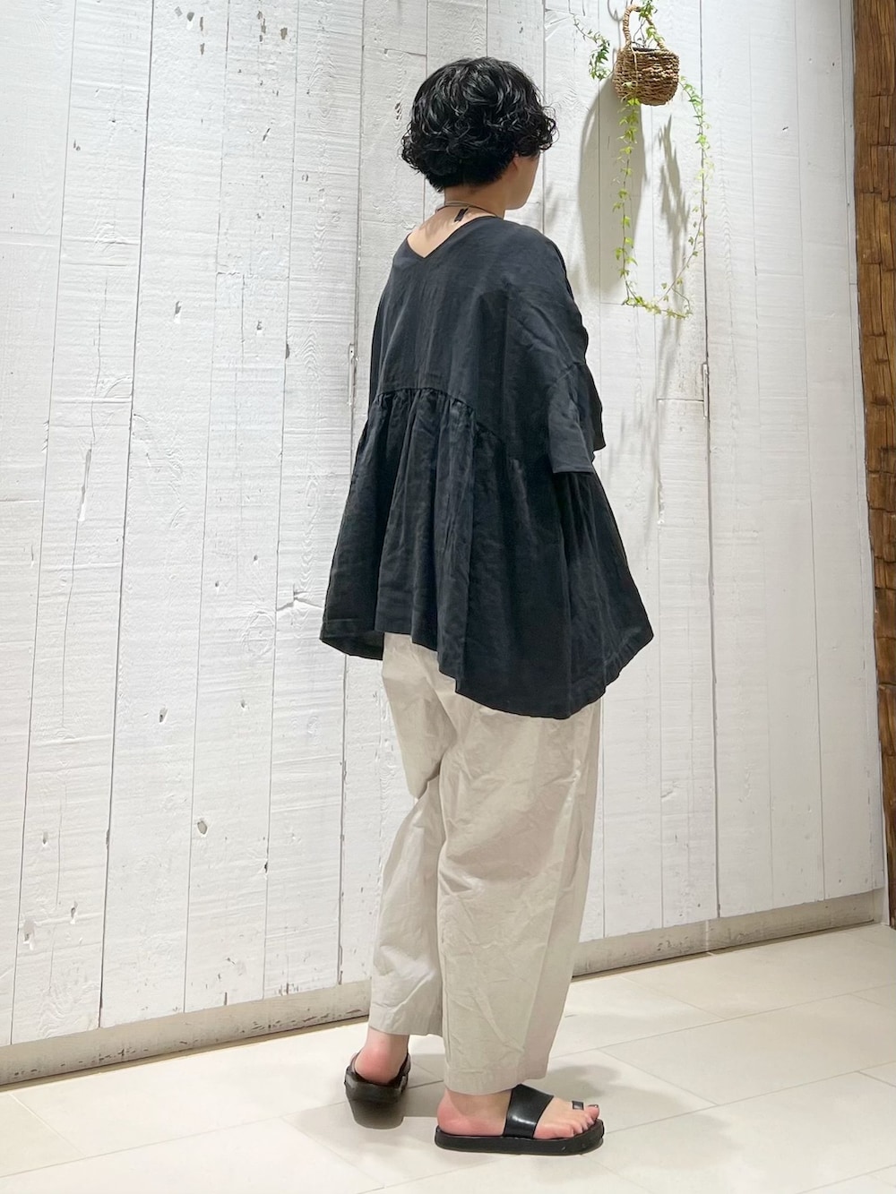グレー系のその他パンツ、ブラック系のシャツ/ブラウス、ブラック系のかごバッグを着用したレディースの夏コーディネートの4枚目の写真