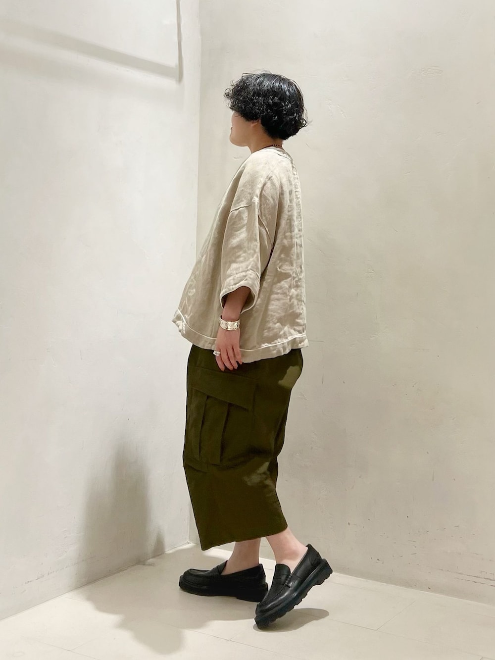 グリーン系のカーゴパンツ、ホワイト系のTシャツ/カットソーを着用したレディースの春コーディネートの2枚目の写真