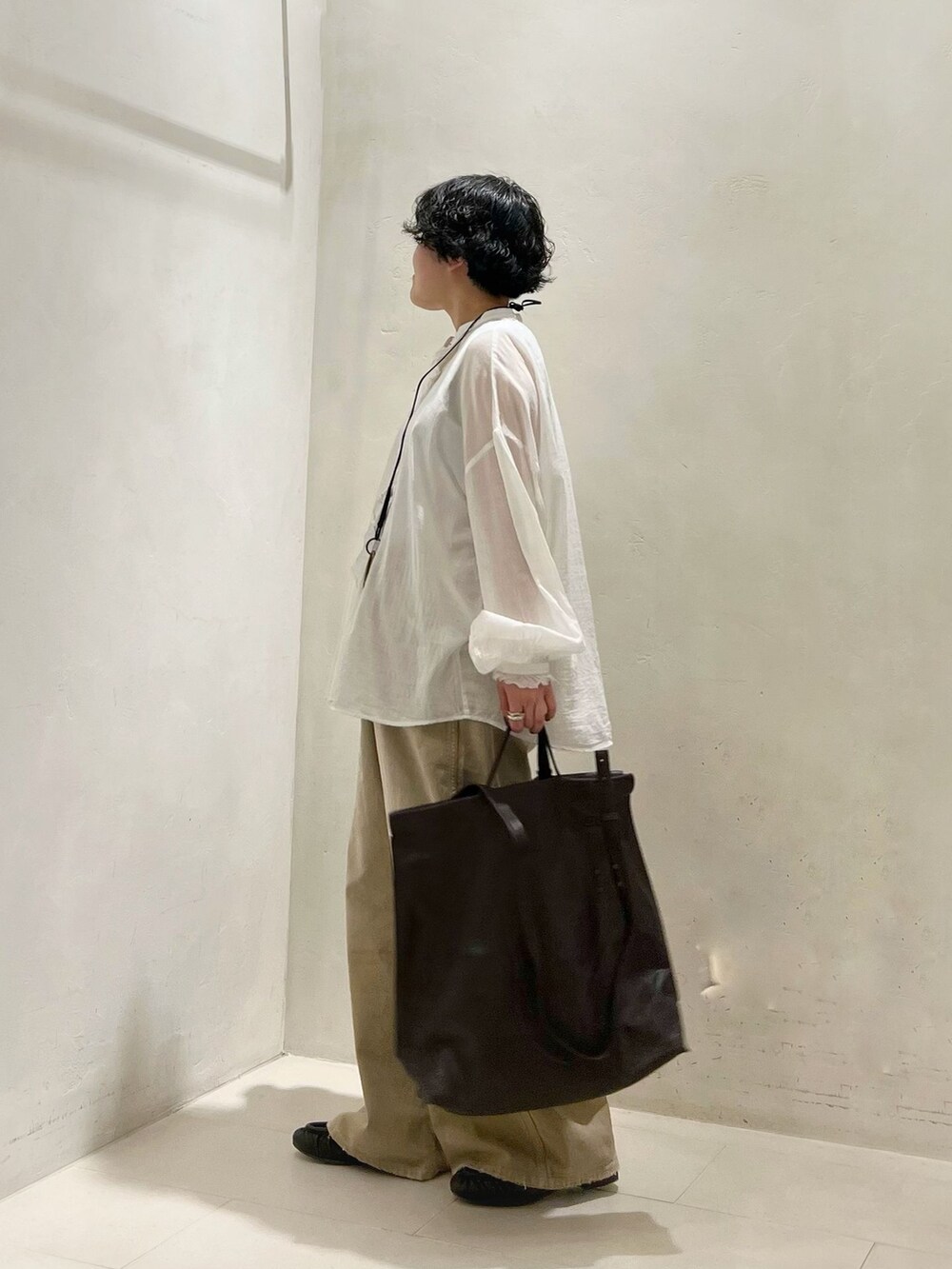 ベージュ系のその他パンツ、ホワイト系のシャツ/ブラウス、ホワイト系のタンクトップを着用したレディースの春コーディネートの2枚目の写真