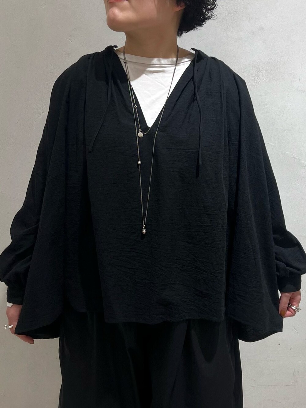 グリーン系のミリタリージャケット、ブラック系のその他パンツ、ホワイト系のTシャツ/カットソーを着用したレディースの冬コーディネートの9枚目の写真