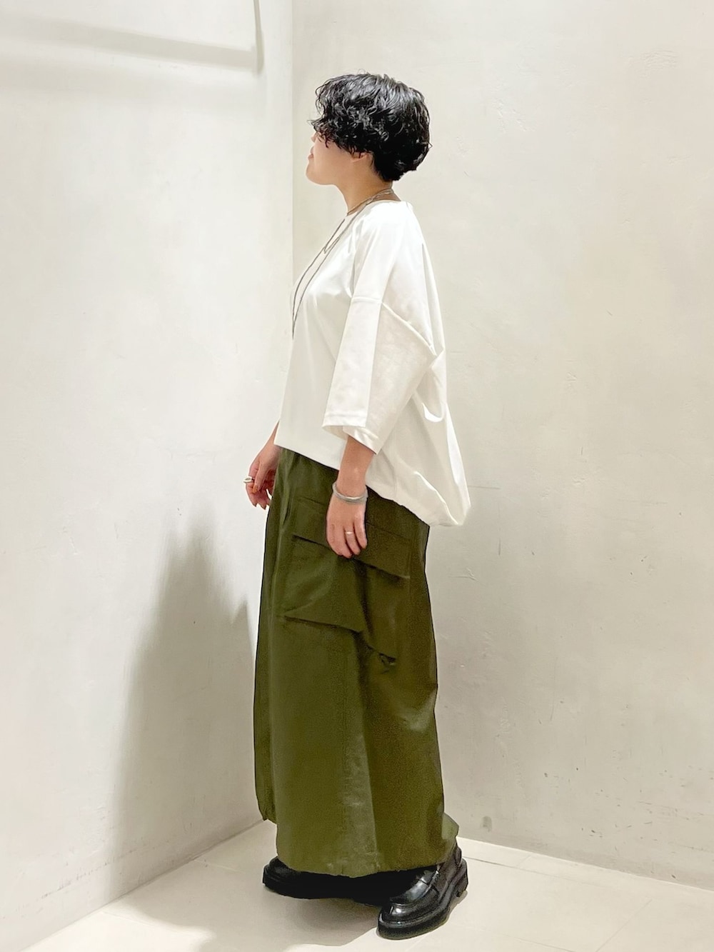グリーン系のスカート、ホワイト系のTシャツ/カットソーを着用したレディースの夏コーディネートの2枚目の写真