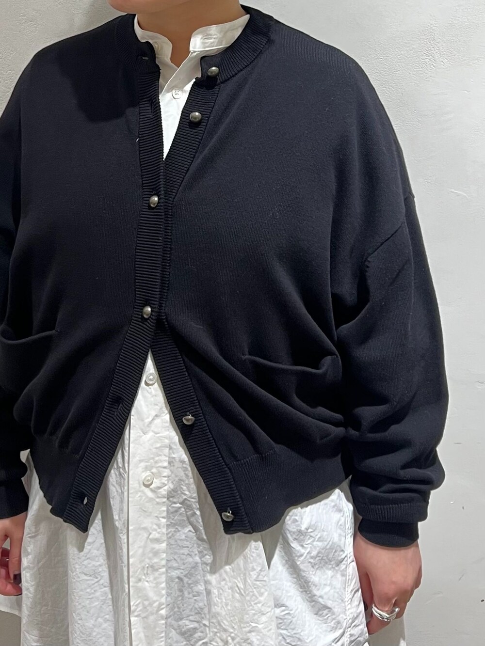ブラック系のカーゴパンツ、ホワイト系のシャツ/ブラウス、ブラック系のニット/セーターを着用したレディースの冬コーディネートの4枚目の写真