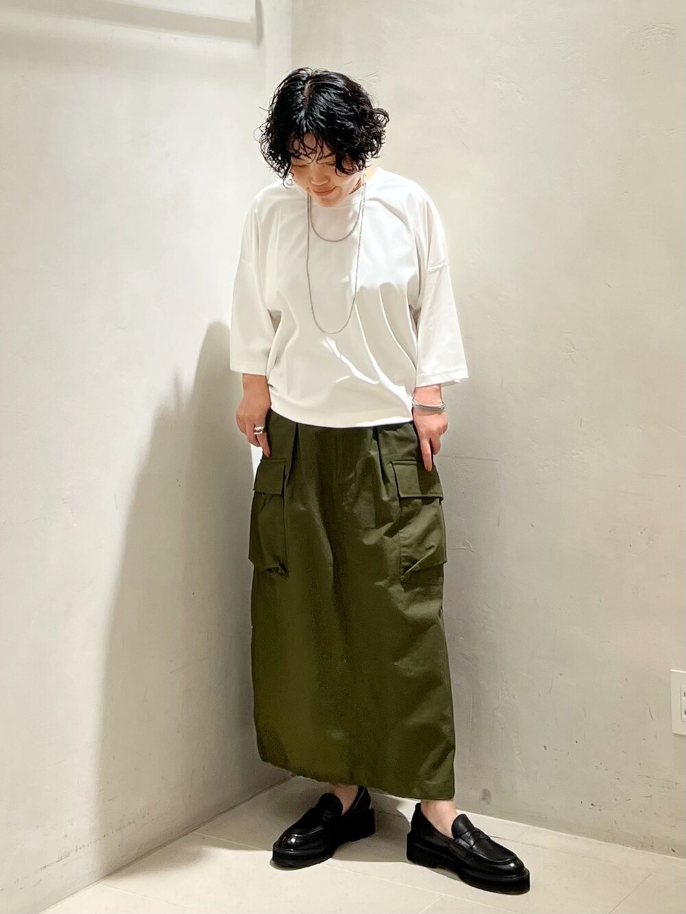 グリーン系のスカート、ホワイト系のTシャツ/カットソーを着用したレディースの夏コーディネートの5枚目の写真