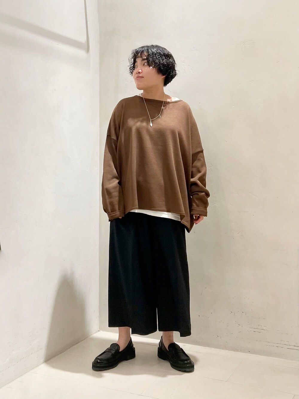 ブラック系のその他パンツ、ホワイト系のTシャツ/カットソー、ブラウン系のニット/セーターを着用したレディースの春コーディネートの5枚目の写真