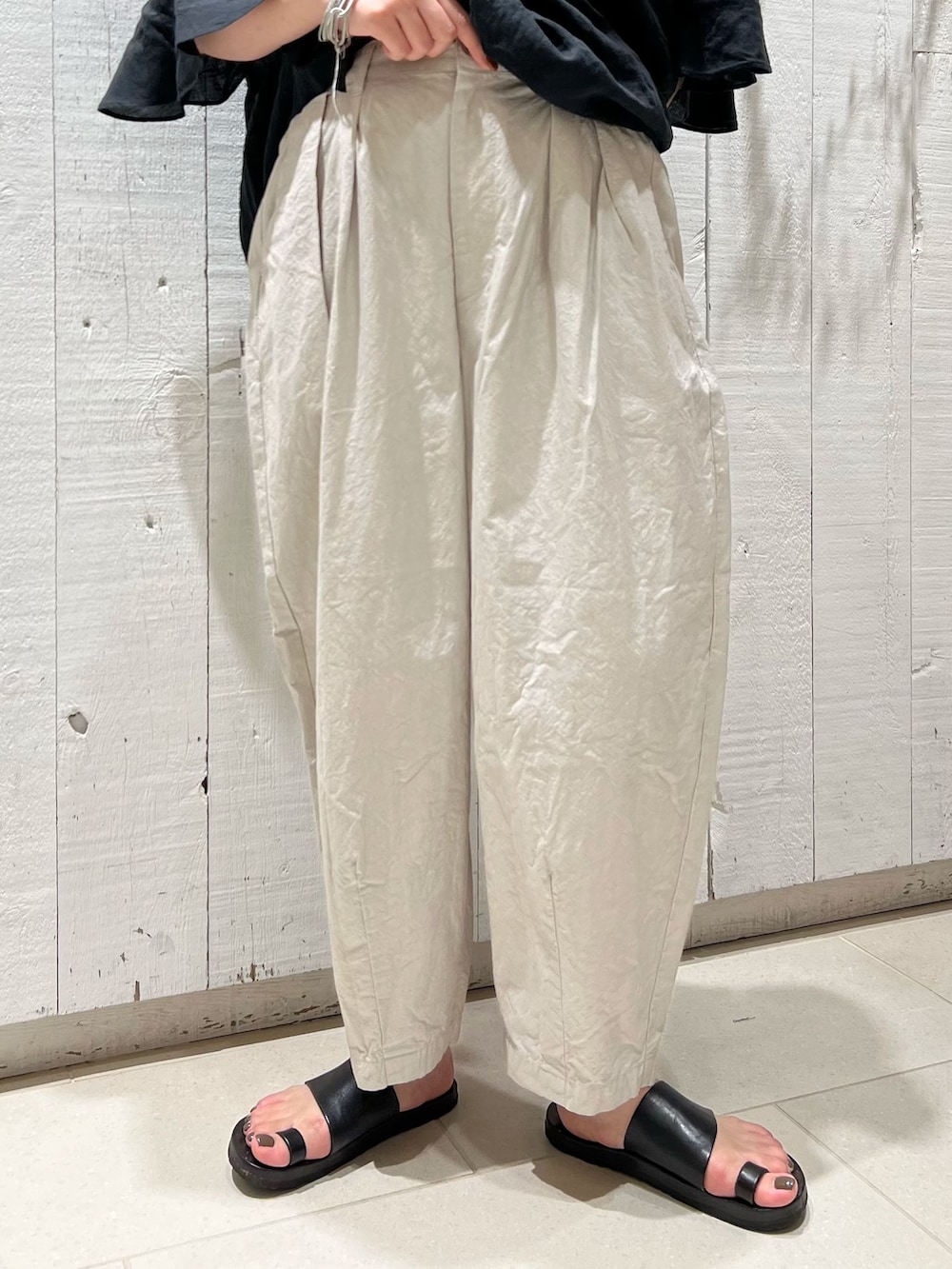 グレー系のその他パンツ、ブラック系のシャツ/ブラウス、ブラック系のかごバッグを着用したレディースの夏コーディネートの7枚目の写真