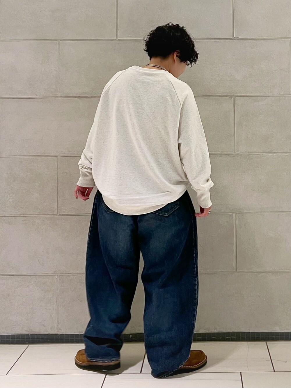 ブルー系のデニムパンツを着用したレディースの秋コーディネートの3枚目の写真