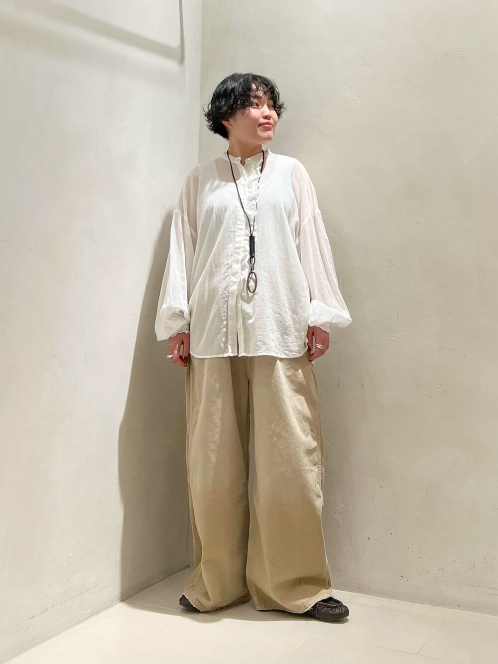 ベージュ系のその他パンツ、ホワイト系のシャツ/ブラウス、ホワイト系のタンクトップを着用したレディースの春コーディネートの4枚目の写真